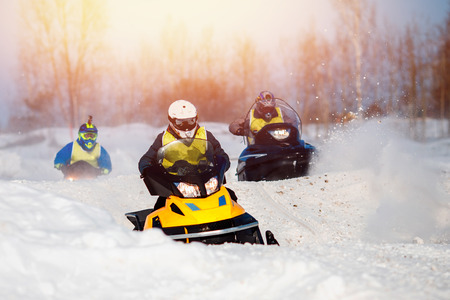 Snowmobile. Snowmobile races in snow. Concept team of friends chasing mountains.の写真素材