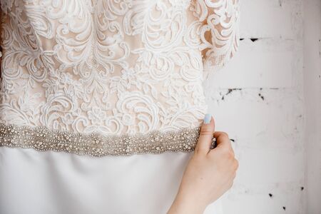 Young woman holding White modern wedding dresses in dress store.の写真素材