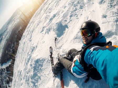 Guy sportsman goes on normal skiing on ski slope with action camera. Sunset. Sheregesh, Kemerovo region, Russia.の写真素材