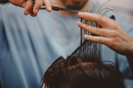 Barbershop. Close-up of man haircut, master does the hair styling in barber shopの写真素材