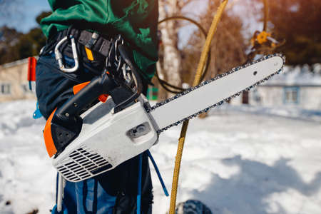 Chainsaw. Close-up of man lumberjack holding chainsaw for cutting down trees.の写真素材