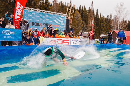 Sheregesh, Kemerovo region, Russia - April 7, 2018: Grelka Fest: Riders jump in carnival costumes in pool.のeditorial素材