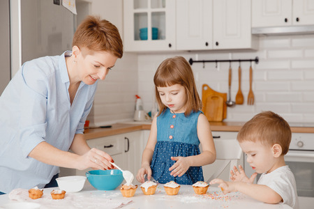 Mom shows my daughter how to decorate cupcake for Easter holiday. Concept education, Christian familyの写真素材