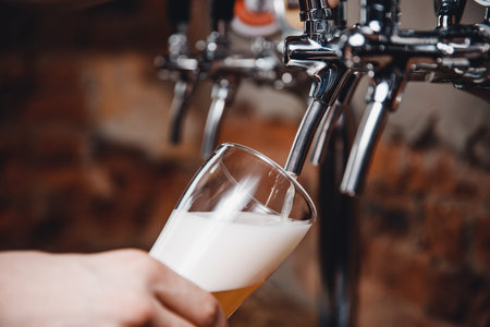 Chrome row cold beer taps with highlights in pub
