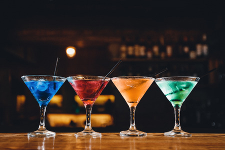 Barman mixes cocktail show with colorful alcoholic cocktails at bar counter.の写真素材
