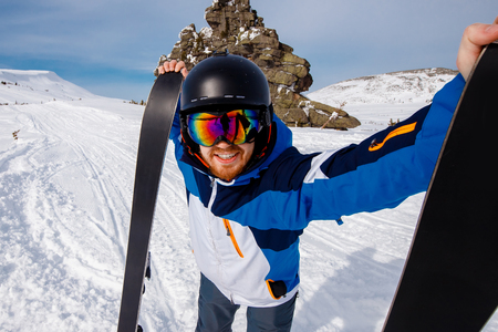 Selfie Guy sportsman goes on normal skiing on ski slope with action camera.の写真素材