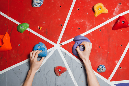 Close-up of artificial hooks and hands of climber on climbing wallの写真素材