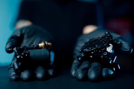 Woman master holding tattoo machine, preparing for drawing pictureの写真素材