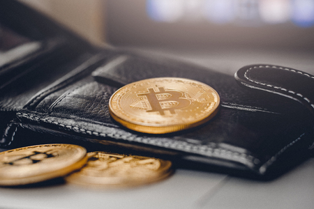 Gold Bitcoin against background of black wallet, concept of crypto currency.の写真素材