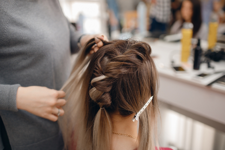 Woman teacher helping students girl training to hairdressersの写真素材