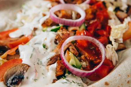 Close-up shawarma sandwich chicken roll in pita with fresh vegetablesの写真素材