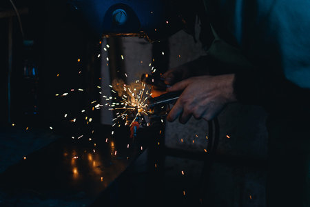 Man worker produces welding work, face mask, flash of light, concept jeweler