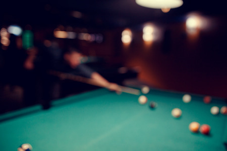 Blurred background men play snooker billiards on table ballsの写真素材