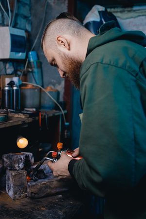 Smith jeweler holds gas burners iron for heating silver metals.の写真素材