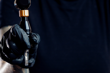 Woman master arm holding tattoo machine, preparing for drawing pictureの写真素材