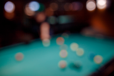 Blurred background men play snooker billiards on table ballsの写真素材