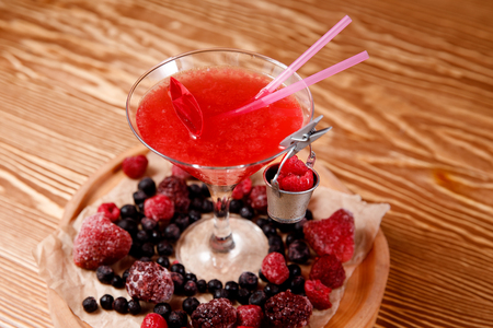 Refreshing cocktail with raspberries and alcohol, red. Decorated with fresh forest berries.の写真素材