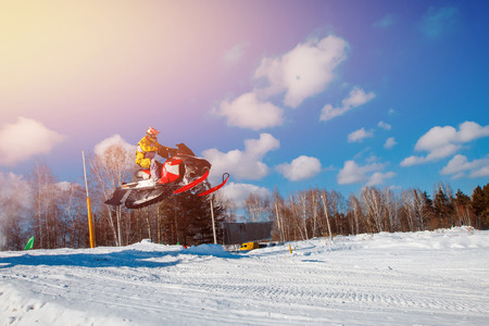 Snowmobile races jump in snow dust. Concept winter extreme sportsの写真素材