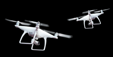 Isolated white drone with twirled propellers on black backgroundの写真素材