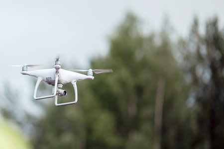 Drone of white color shoots recording concert, in background green. Concept video technology.の写真素材