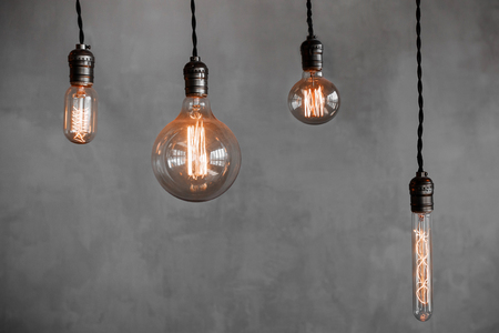 Edison retro lamp Incandescent bulbs on gray plaster wall background in cafe. Concept ideaの写真素材