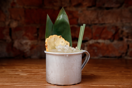 Refreshing cocktail with pineapple, ice and alcohol in an aluminum mugの写真素材