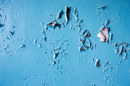Texture paint old, peeled off pieces from wall, blue background. Concept solar radiation, corrosion.の写真素材