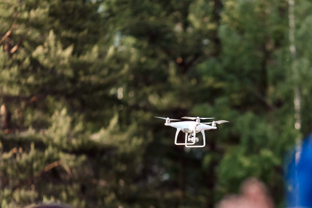 Drone of white color shoots recording concert, in background green. Concept video technology.の写真素材