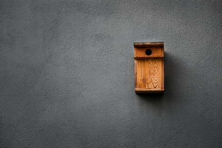 Birdhouse on black gray wall. Copy spaceの写真素材