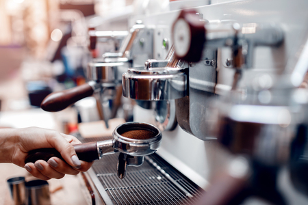 Young barista woman is preparing coffee machine for making espresso. Tamper Filter holderの写真素材