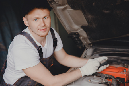 Car mechanic working diagnostic equipment at automotive service.の写真素材