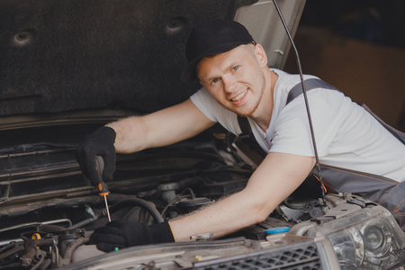 Car mechanic working diagnostic equipment at automotive service.の写真素材