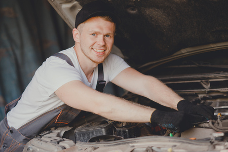 Car mechanic working diagnostic equipment at automotive service. Cleaning air filter.の写真素材