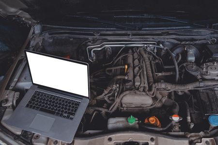 Professional car mechanic using electrnoic diagnostic equipment laptop in auto repair service.の写真素材