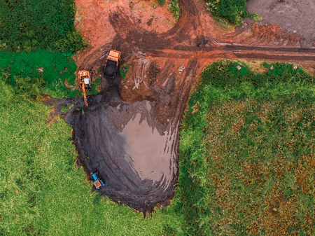 Pond cleaning by tractor, removal of silt waterlogging, treatment plant. aerial view dronの写真素材