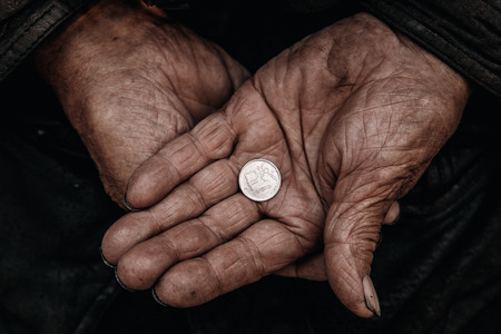 Concept Devaluation of ruble. Dirty hands old man poor with coinの写真素材