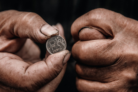 Concept Pension of Russia. Dirty hands old man poor with coin ruble.
