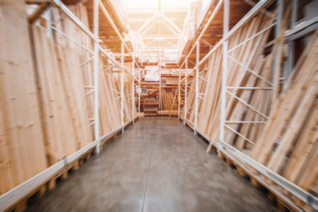 Warehouse industrial premises for storing materials and wood. Concept logistics, transport. Motion blur effect. Bright sunlight.の写真素材
