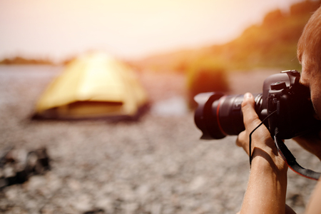 Photographer in journey selects angle and takes photo on professional camera, concept lifestyle bloggerの写真素材
