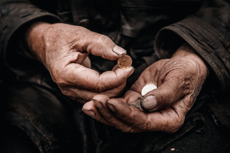 Concept Devaluation of ruble. Dirty hands old man poor with coinの写真素材