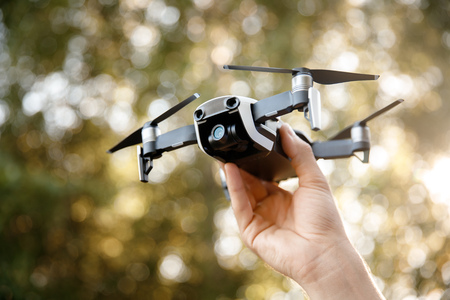Drone takes off from man hand in park. Technology concept of blogger photographer.の写真素材