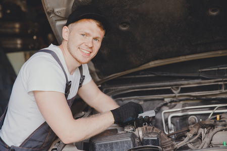 Car mechanic working diagnostic equipment at automotive serviceの写真素材