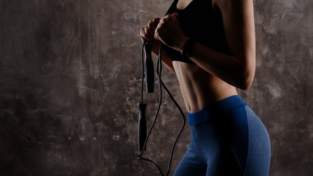 Young woman in sportswear holding skipping rope her hands . Concept workout body. Bannerの写真素材