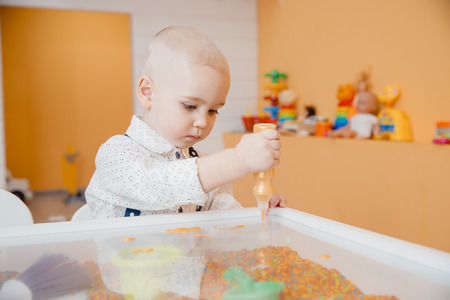 Child paints table with paint on transparent glass, concept development of kid motor skills of hands and art.の写真素材