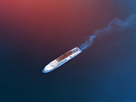 Top view drone of white boat sailing in blue seaの写真素材