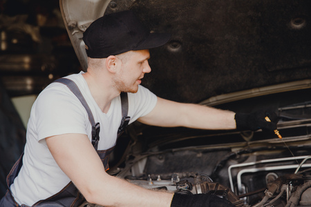 Car mechanic working diagnostic equipment at automotive serviceの写真素材