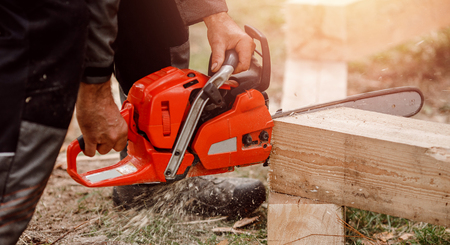 Man builder of houses saws tree with chainsaw. bannerの写真素材