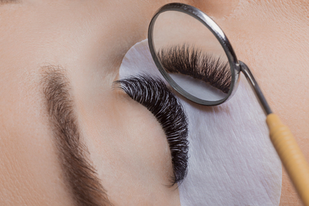 Eyelash extension procedure. Woman eye with beauty lashesの写真素材