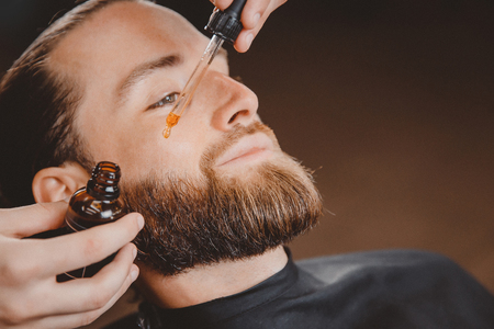 Oil for beard in dropper, process of moisturizing hair.の写真素材