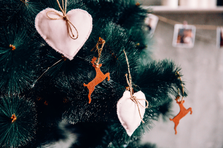 Close-up of a Christmas tree with deers and hearts made of felt.の写真素材